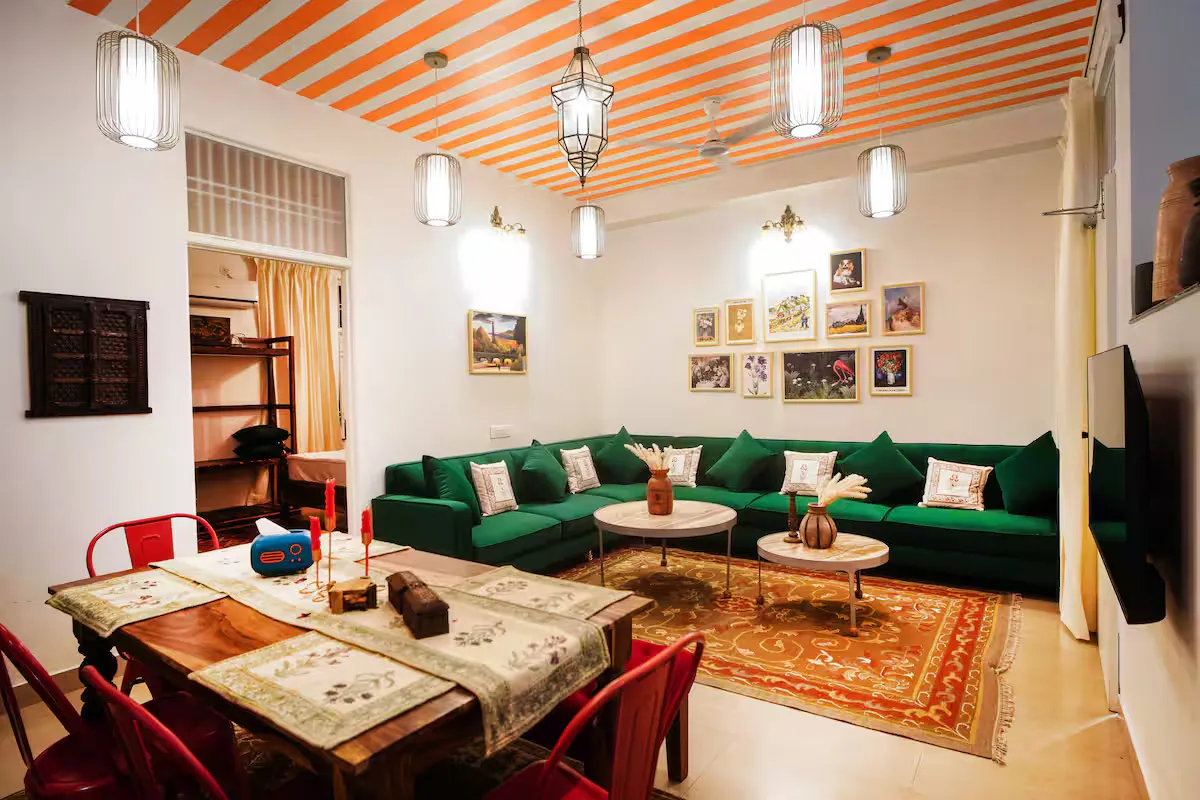 Aurora Luxe Residence — living room with striped ceiling, emerald sofas and exclusive rugs, Jaipur