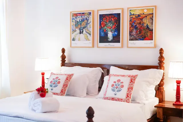 Aurora Luxe Residence — four-poster bedroom with European artworks