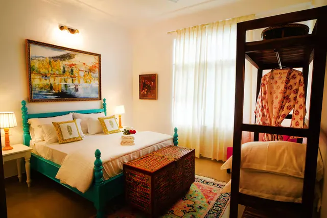 Met Luxe Galleria — bedroom with teal four-poster bed and antiques