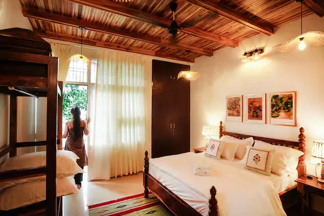Timber Luxe Ateliér — artful bedroom beneath carved wood ceilings
